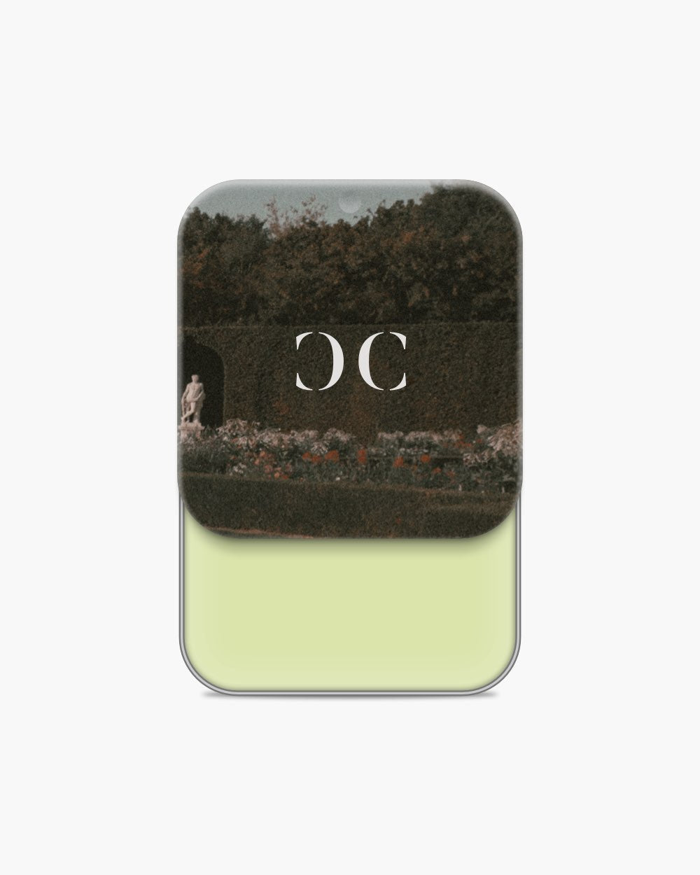Seint Cream Corrector open to a pale pistachio-green cream, vintage garden scene with statue on the lid