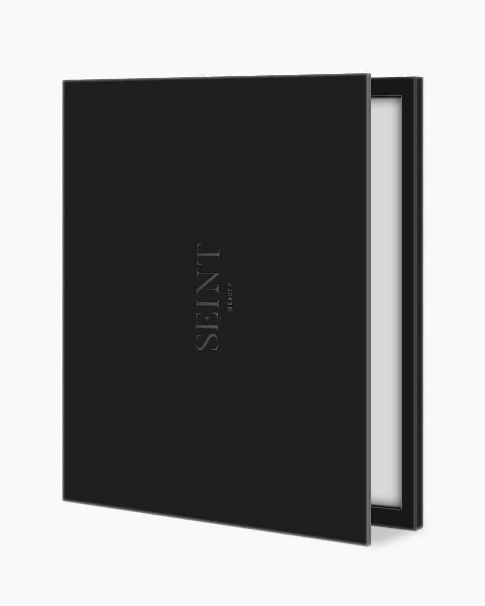 Seint Cream Corrector Palette 49, a large square matte black case with SEINT wordmark, slightly open to reveal its mirror