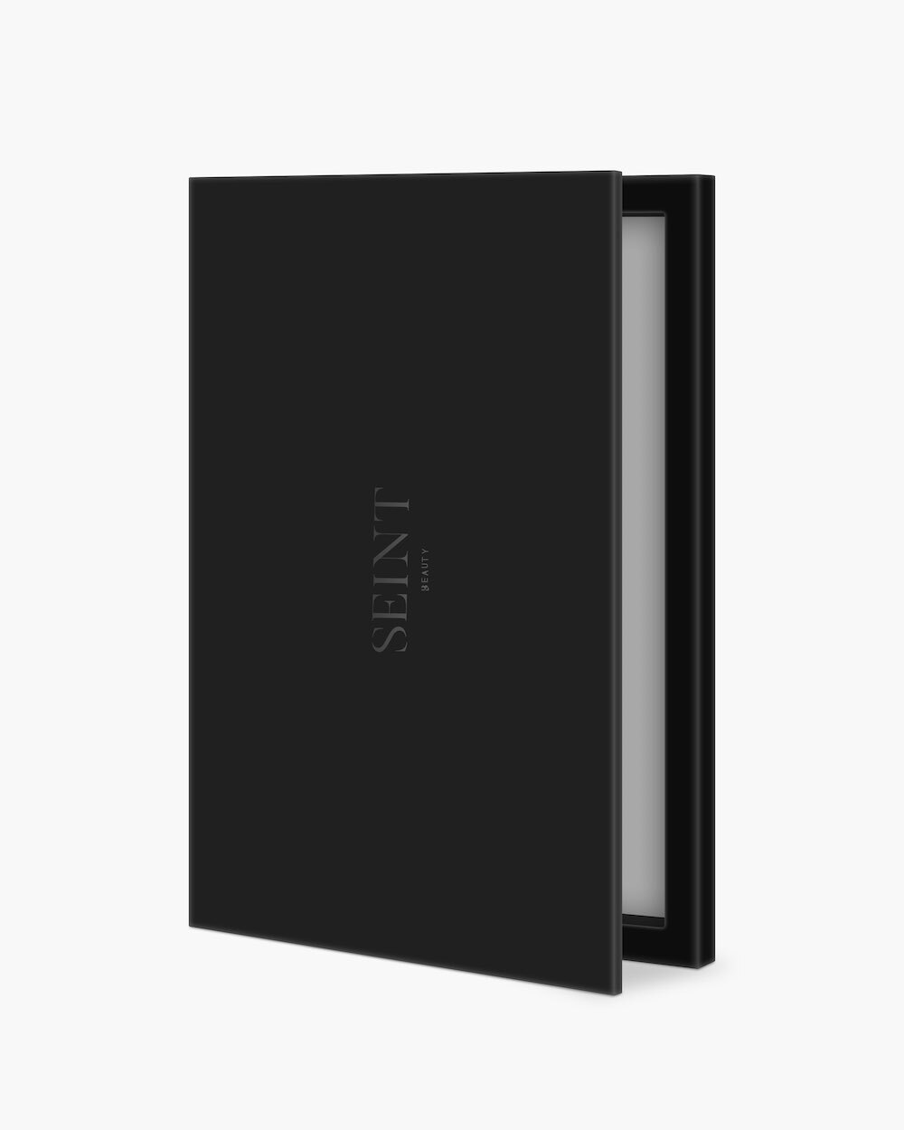 Seint Cream Corrector Palette 20 in matte black, standing slightly open with the SEINT wordmark and mirror edge visible