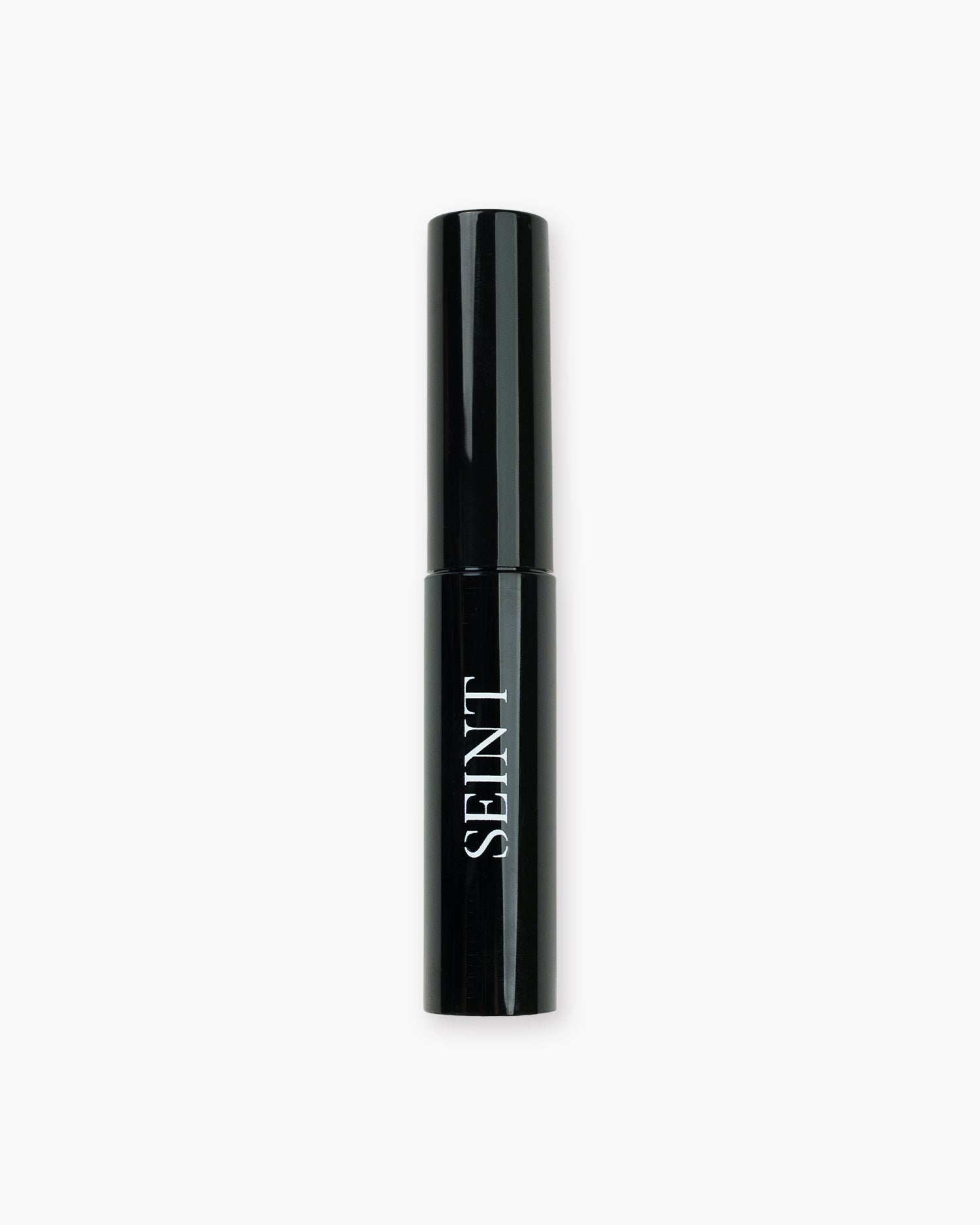 Seint Archangel Brow Gel in a slim glossy black tube with white SEINT wordmark, closed and standing upright