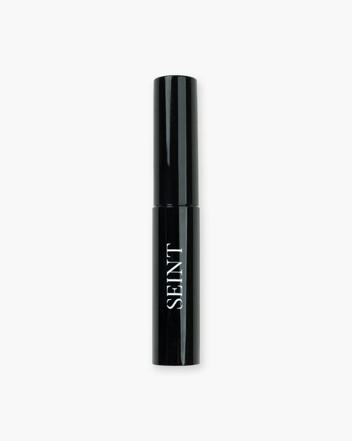 Seint Archangel Brow Gel in a slim glossy black tube with white SEINT wordmark, closed and standing upright