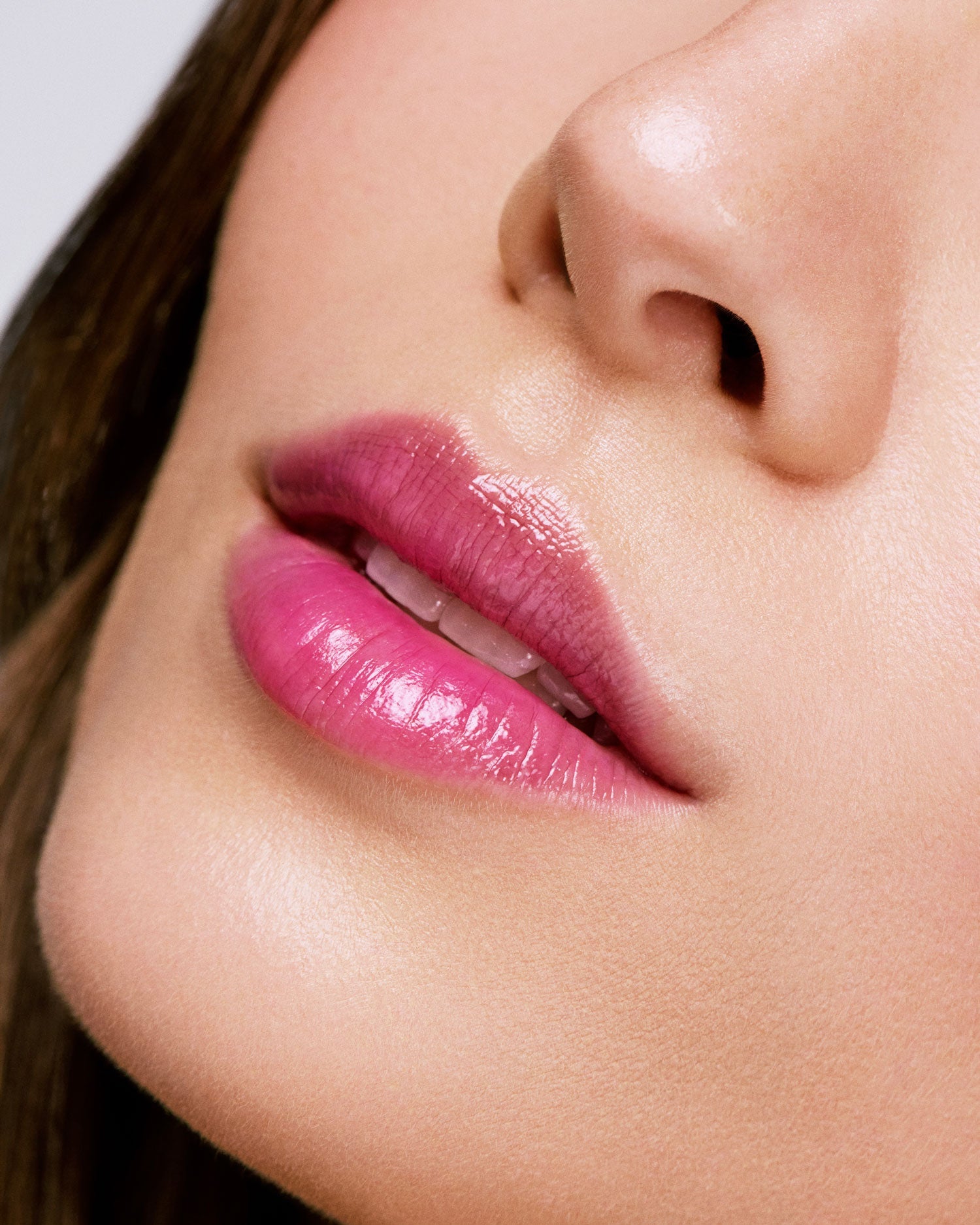 Seint Blackberry Lip Flush worn on a model's lips, a sheer glossy berry-pink tint in extreme close-up