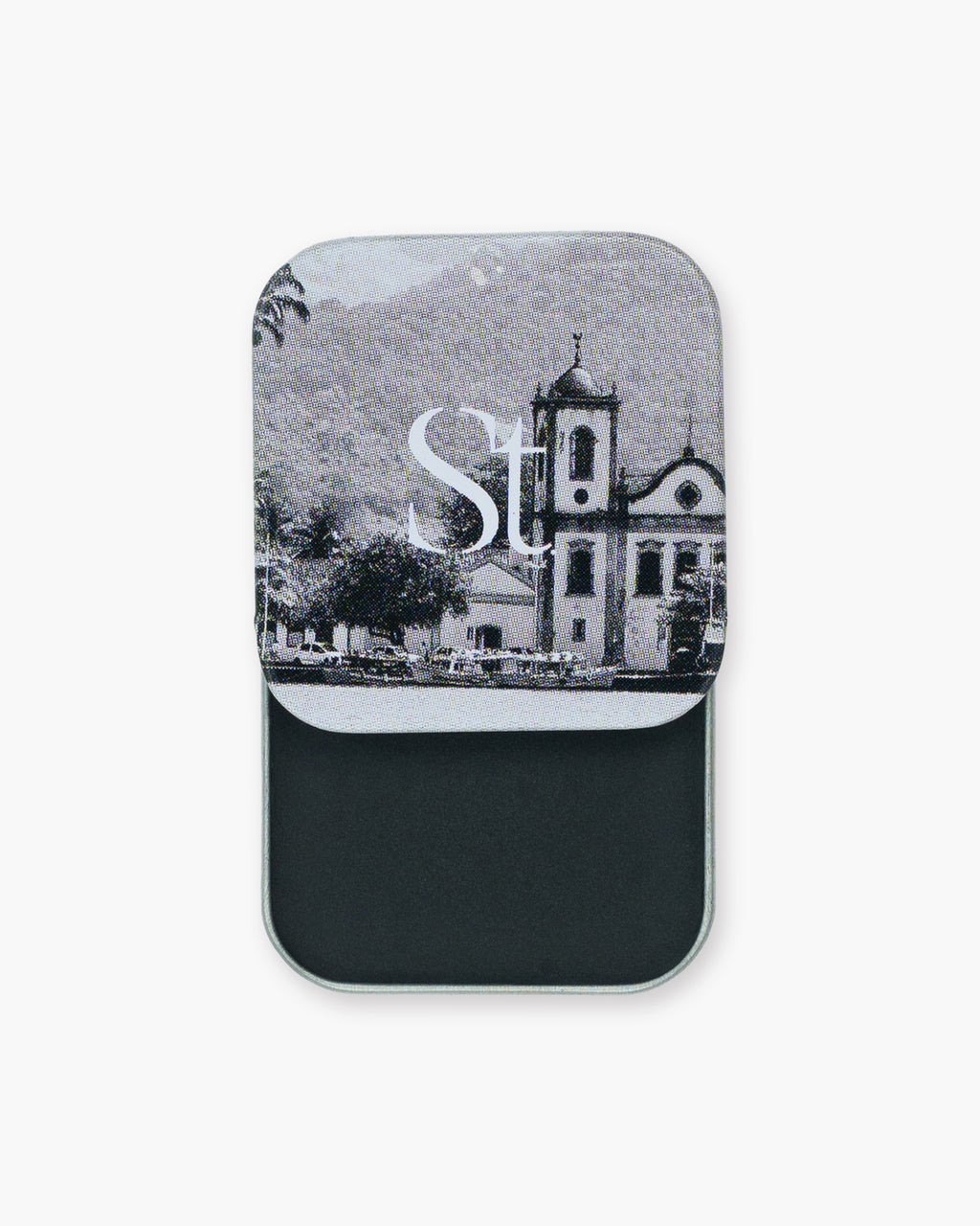 Seint Eyeliner slide tin open to jet-black cream, its lid printed with a black-and-white church scene