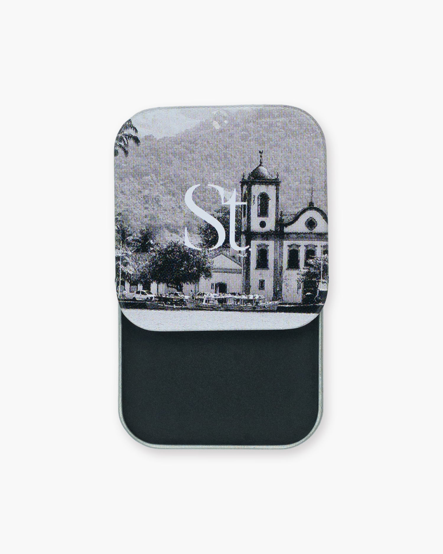 Seint Eyeliner slide tin open to jet-black cream, its lid printed with a black-and-white church scene