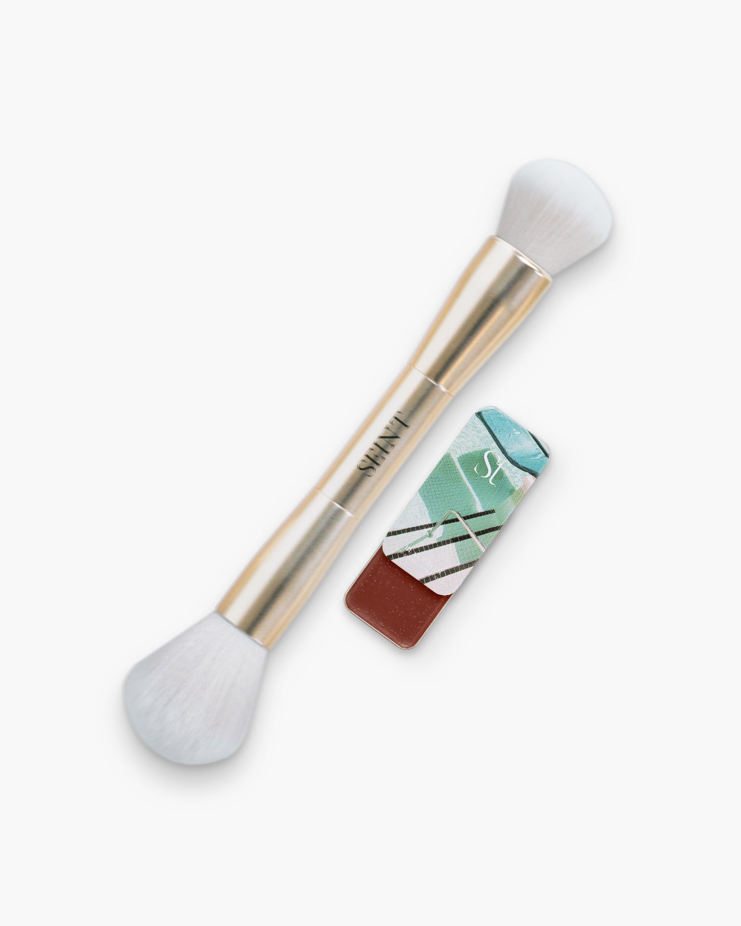 Seint Bronzer Bundle: Heatwaves cream bronzer, a deep russet brown, next to the double-ended gold brush
