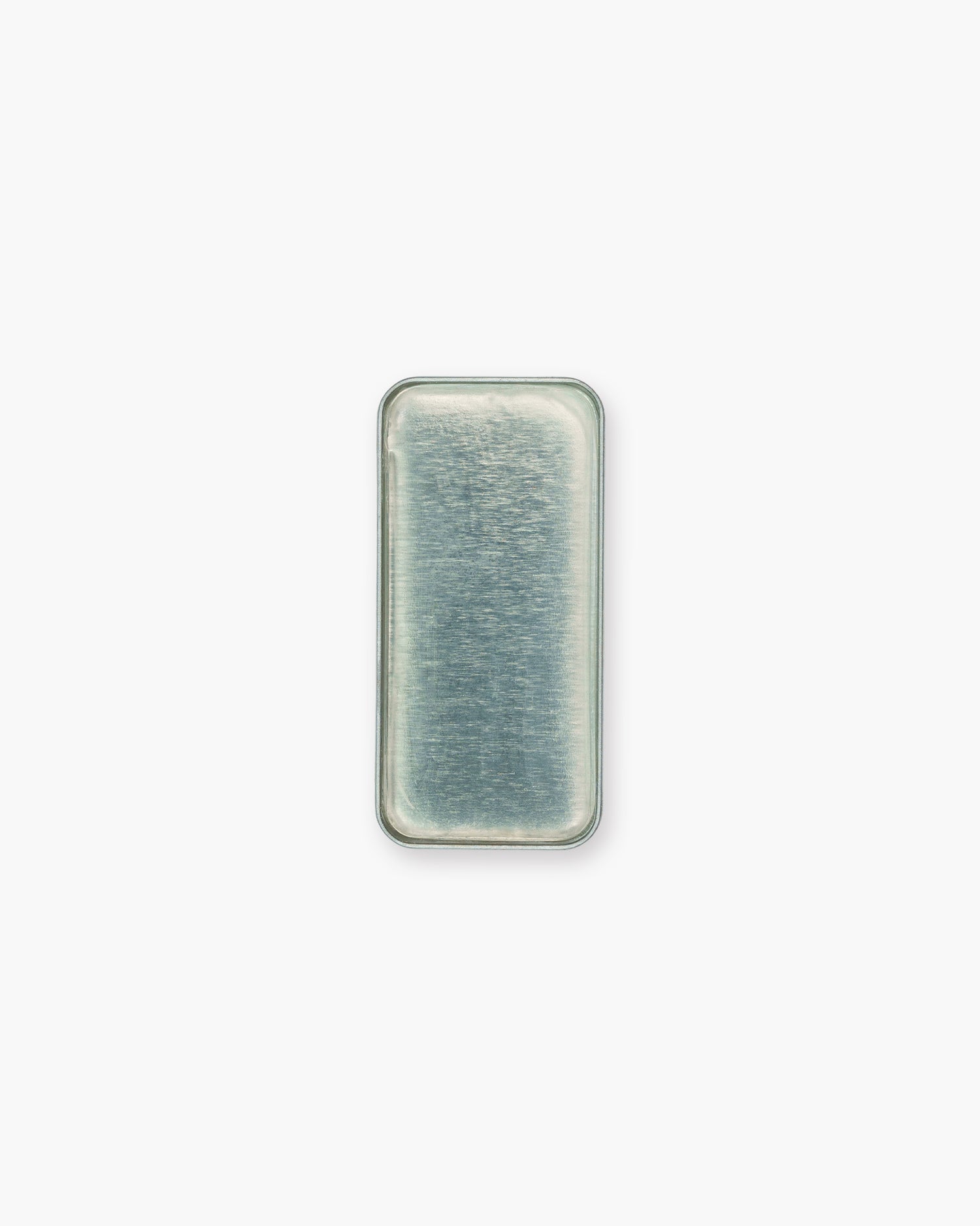 Seint Brow Wax seen from above, the clear colorless wax filling its rectangular metal tray