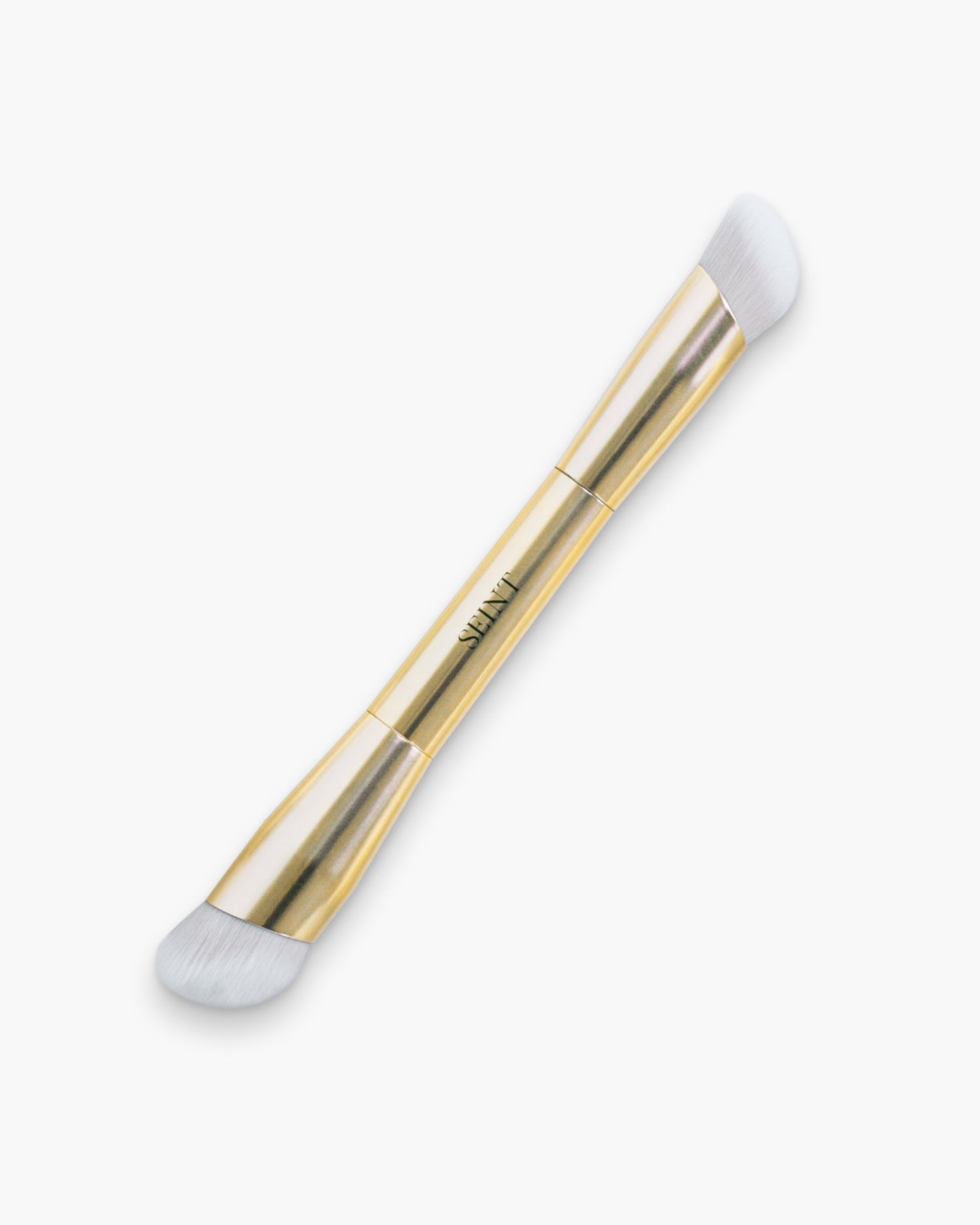 Seint Buff Brush in gold — double-ended brush with two angled heads of dense white bristles in different sizes
