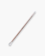 Seint Eyeshadow Brush in rose gold, its soft white bristle tips at each end of the slender metal handle