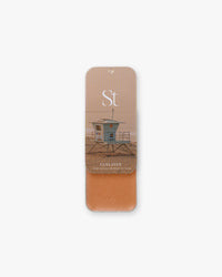 Seint Bronzer in Tanlines, slide-open tin with lifeguard tower lid art and a light peachy-tan cream