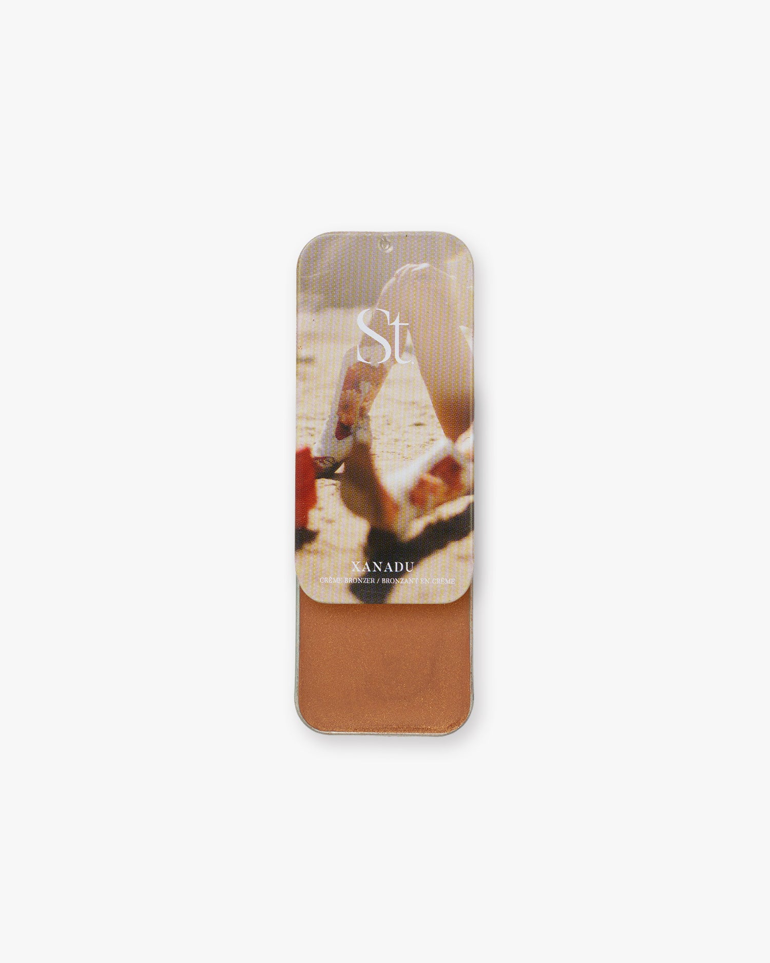 Seint Bronzer in Xanadu, slide-open tin with beach scene lid art revealing a shimmery copper-bronze cream