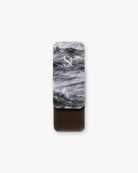 Seint Contour in Cola: stormy ocean-wave lid art, tin slid open to a deep espresso-brown cream