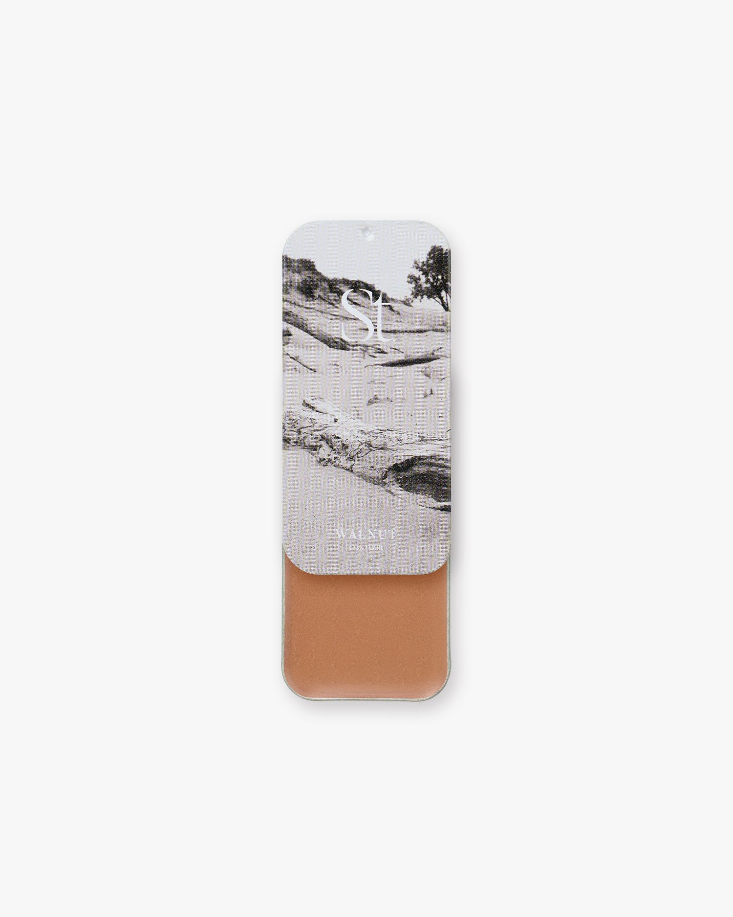 Seint Contour in Walnut: tin slid open to a warm caramel cream, lid showing monochrome sand dunes and driftwood