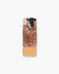 Seint Highlight in Amber: golden caramel cream under a lid with a faceted amber glass perfume bottle