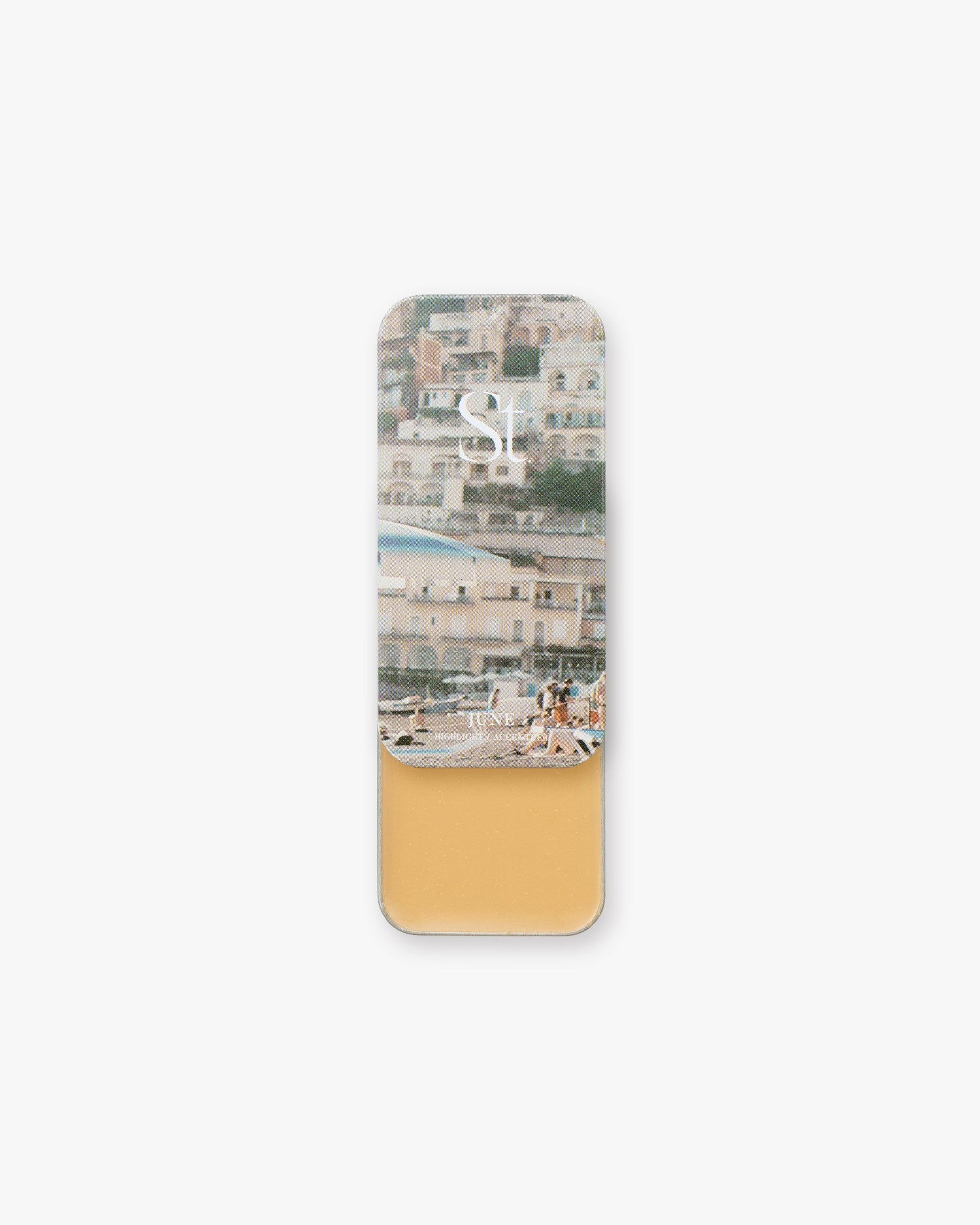 Seint Highlight in June: golden honey-tan cream in an open tin, lid showing an Italian seaside village beach