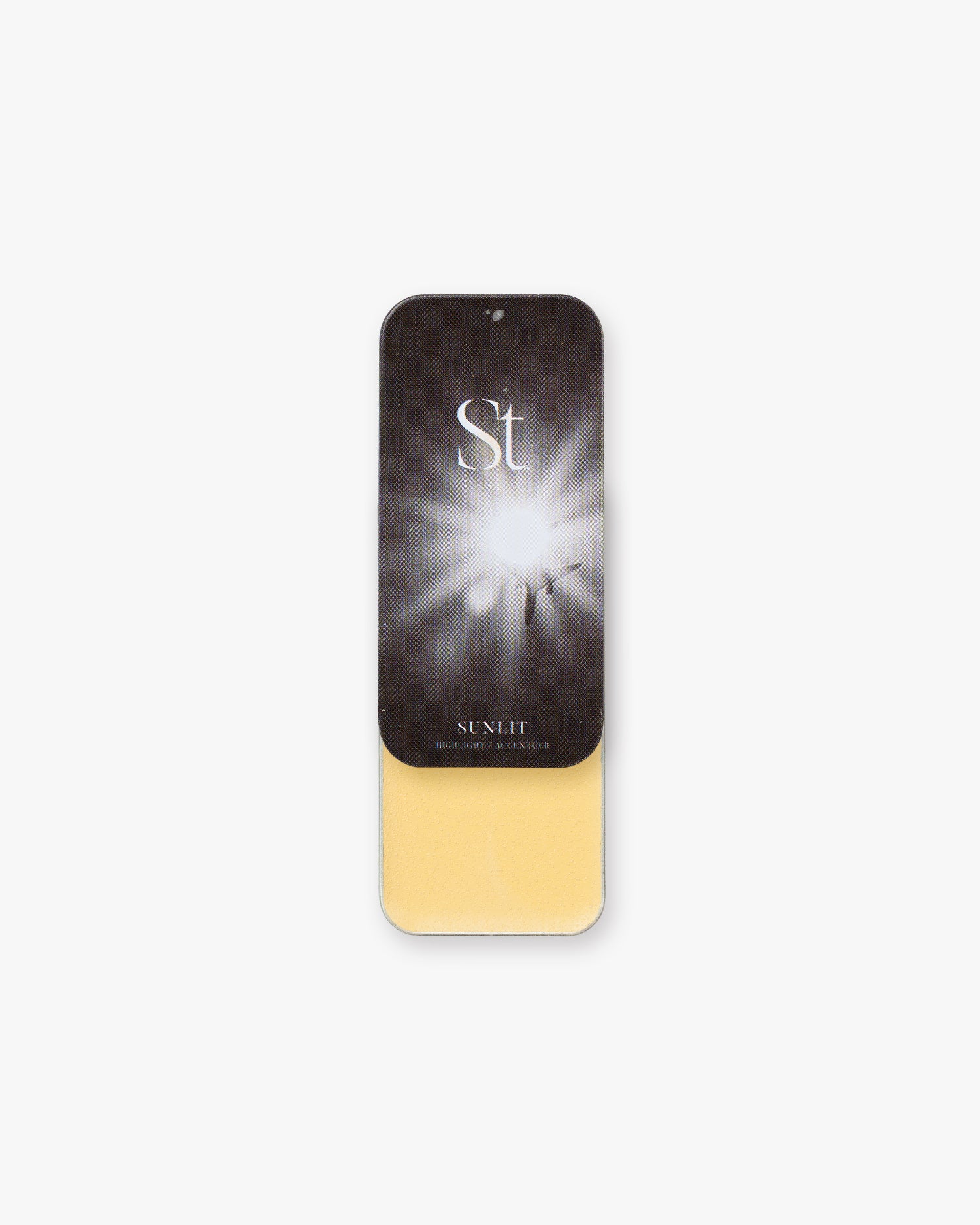Seint Highlight in Sunlit: soft buttery-yellow cream under a dark lid with a radiant burst of light