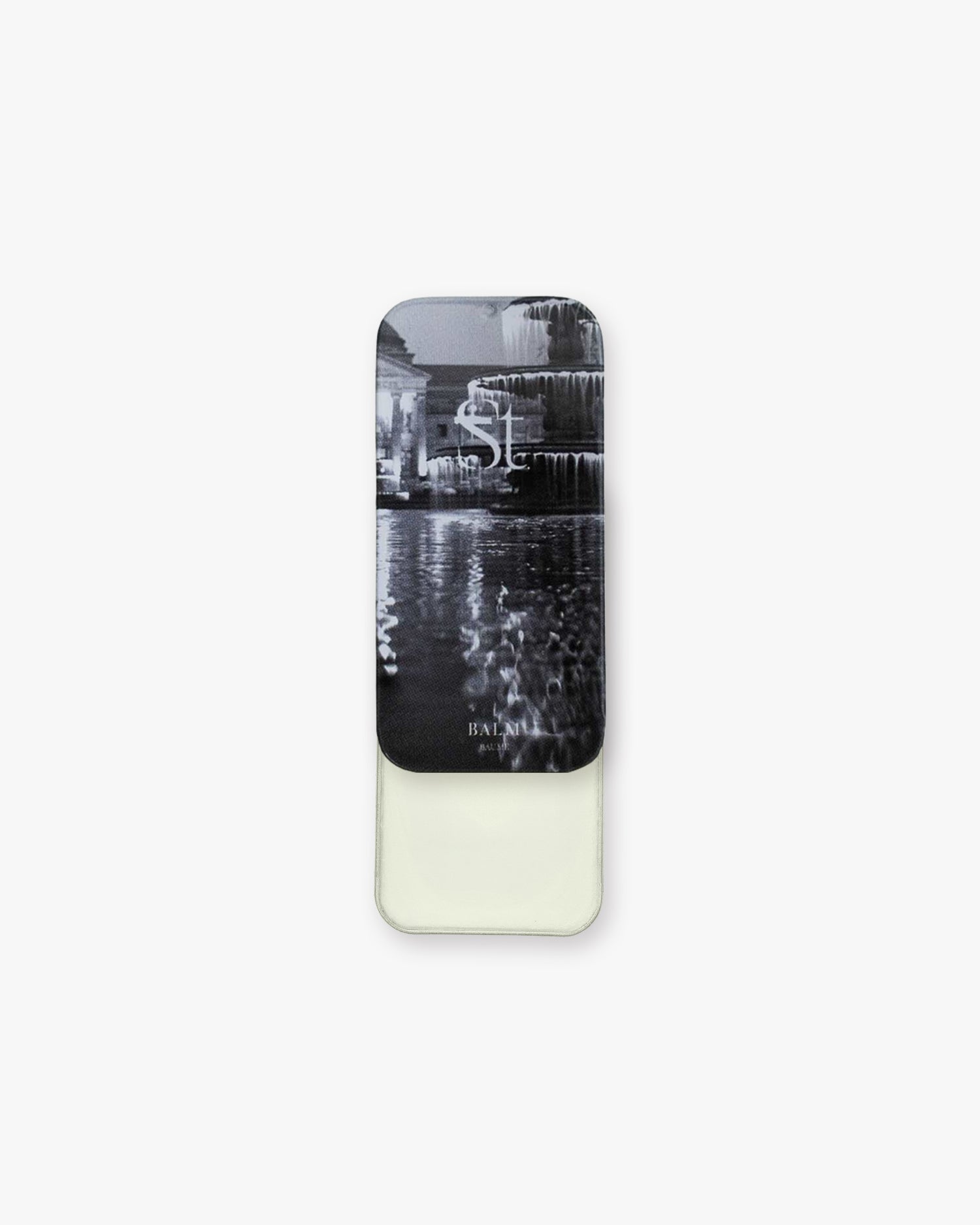 Seint Balm - Unscented slim metal tin slid open to pale ivory balm, lid printed with a black-and-white fountain scene