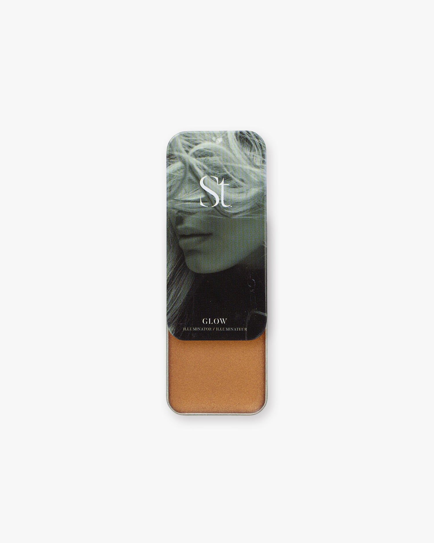Seint Illuminator in Glow slide-top tin, opened to a warm golden-bronze cream below a green-toned portrait lid