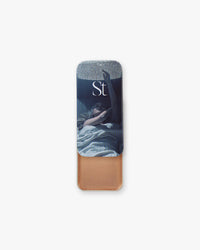 Seint Illuminator in Nova, tin slid open revealing shimmery copper-bronze cream beneath blue-toned lid artwork