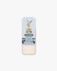 Seint Illuminator in Pearl, tin slid open to soft ivory cream beneath lid art of a gilded winged statue