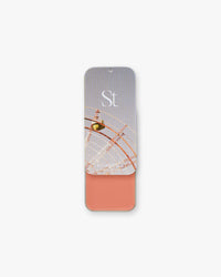 Seint Lip + Cheek in Boardwalk, gloss finish — soft peachy-coral cream blush shown in an open slide tin