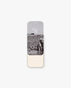 Seint Setting Powder tin in Vanilla Dust slid open to reveal soft ivory powder beneath a black-and-white beach lid