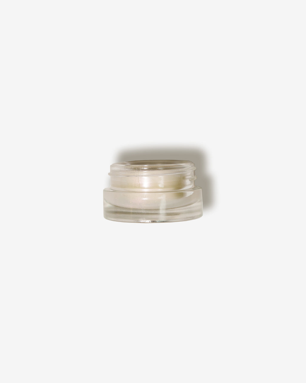 Seint Lip Balm in a clear glass jar with the lid removed, showing the pearlescent off-white balm inside