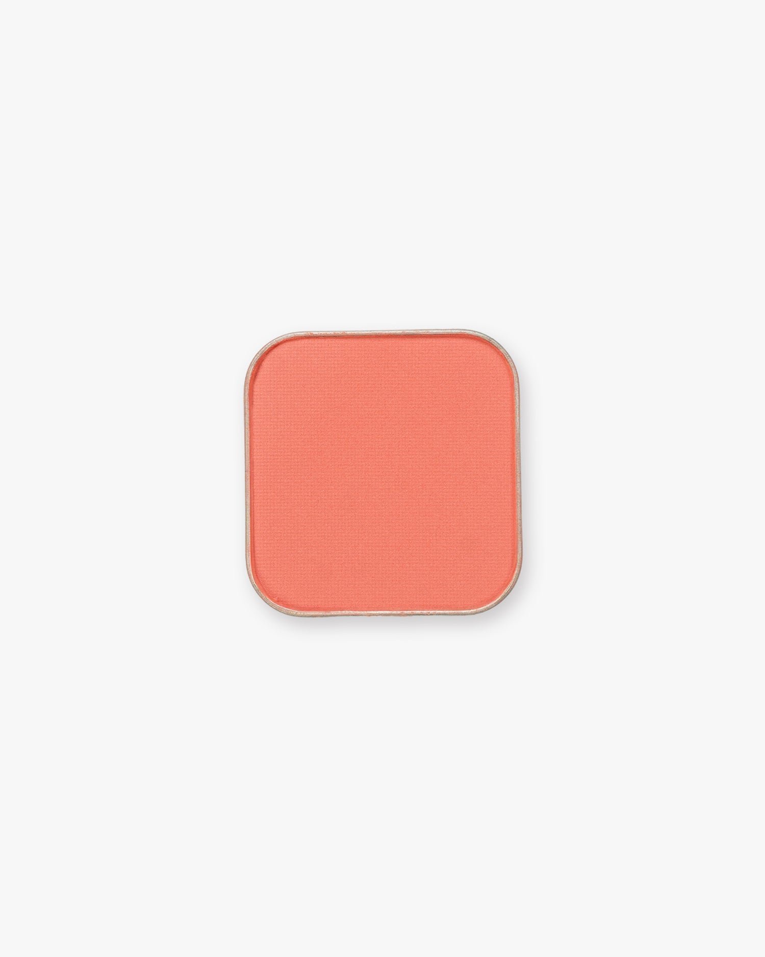 Seint Pressed Pigment in Coral, a warm peachy-coral matte powder in its metal pan