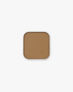 Warm caramel-tan Seint Pressed Pigment in Cowboy, pictured in its square metal tin