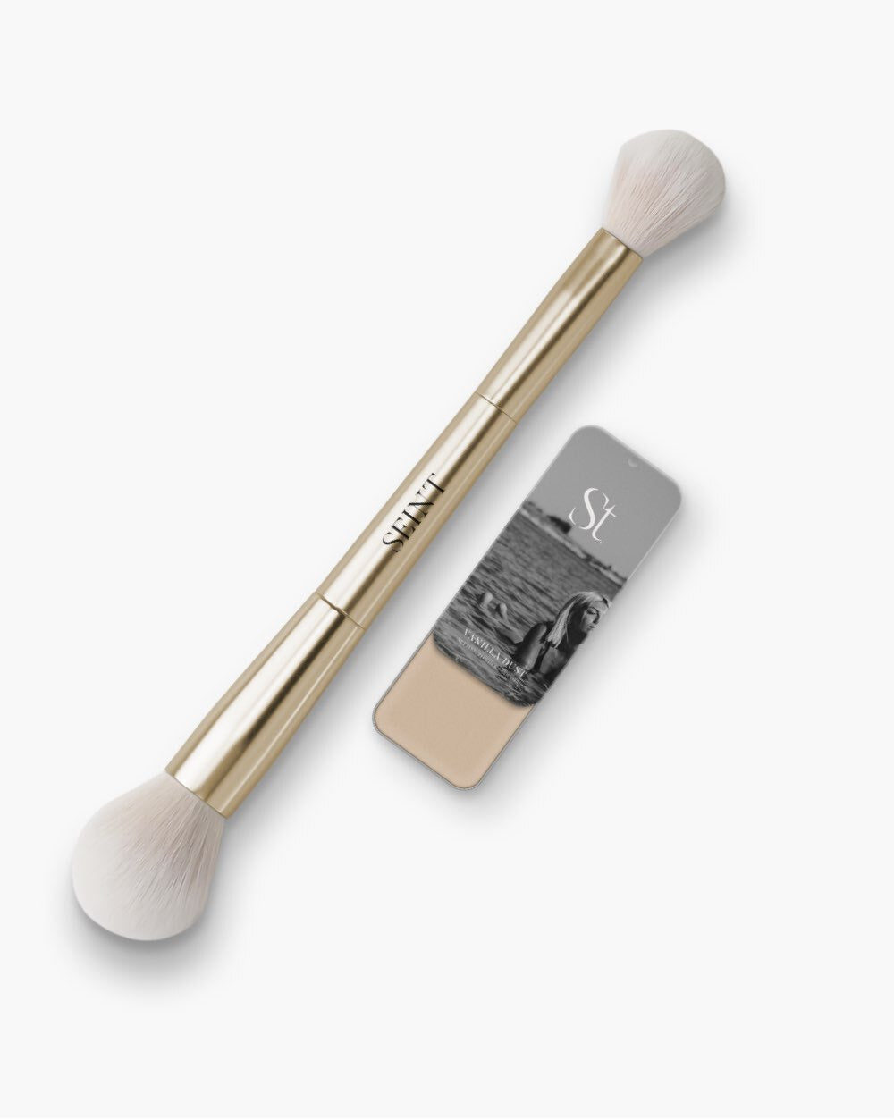 Seint Powder Bundle — gold double-ended brush beside a Vanilla Dust tin slid open to show creamy ivory setting powder
