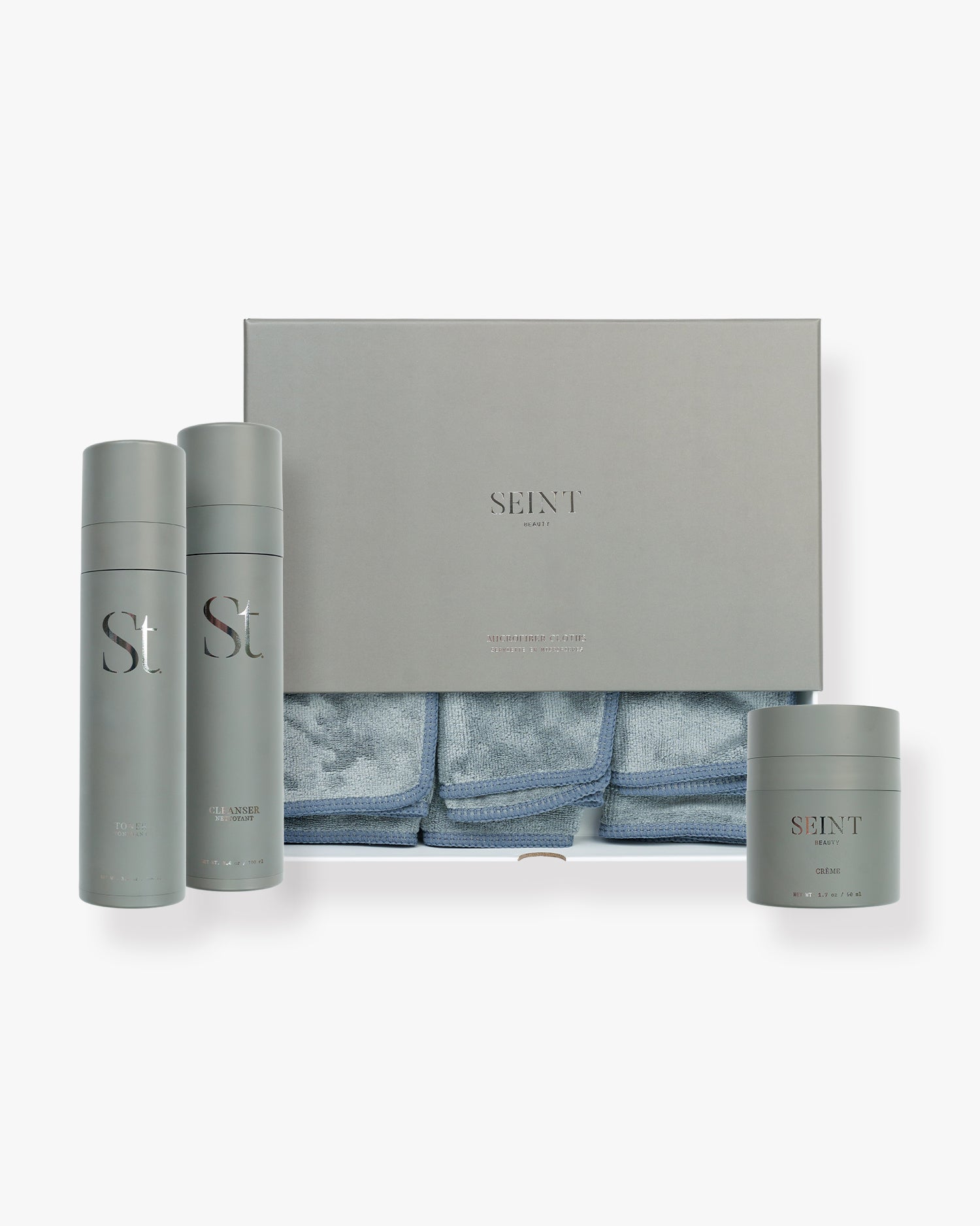 Seint Skincare Bundle: sage-gray Cleanser and Toner bottles, Crème jar, and a box of blue microfiber cloths