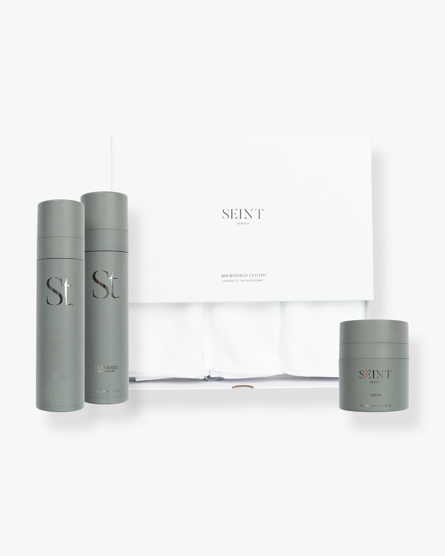 Seint Skincare Bundle with white microfiber cloths — sage-gray Toner, Cleanser, and Crème beside the SEINT cloths box