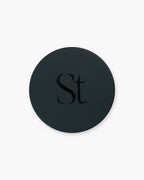 Seint Brush Cleansing Soap round black tin closed, its lid marked with the Seint monogram