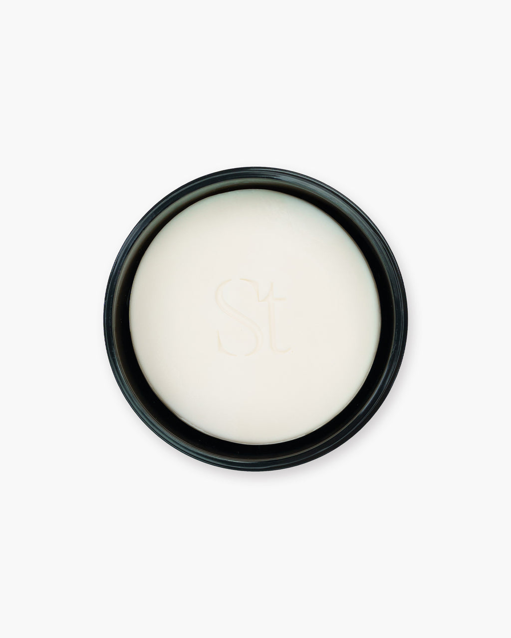 Seint Brush Cleansing Soap bar in creamy white, embossed with the monogram and nested in its open black tin