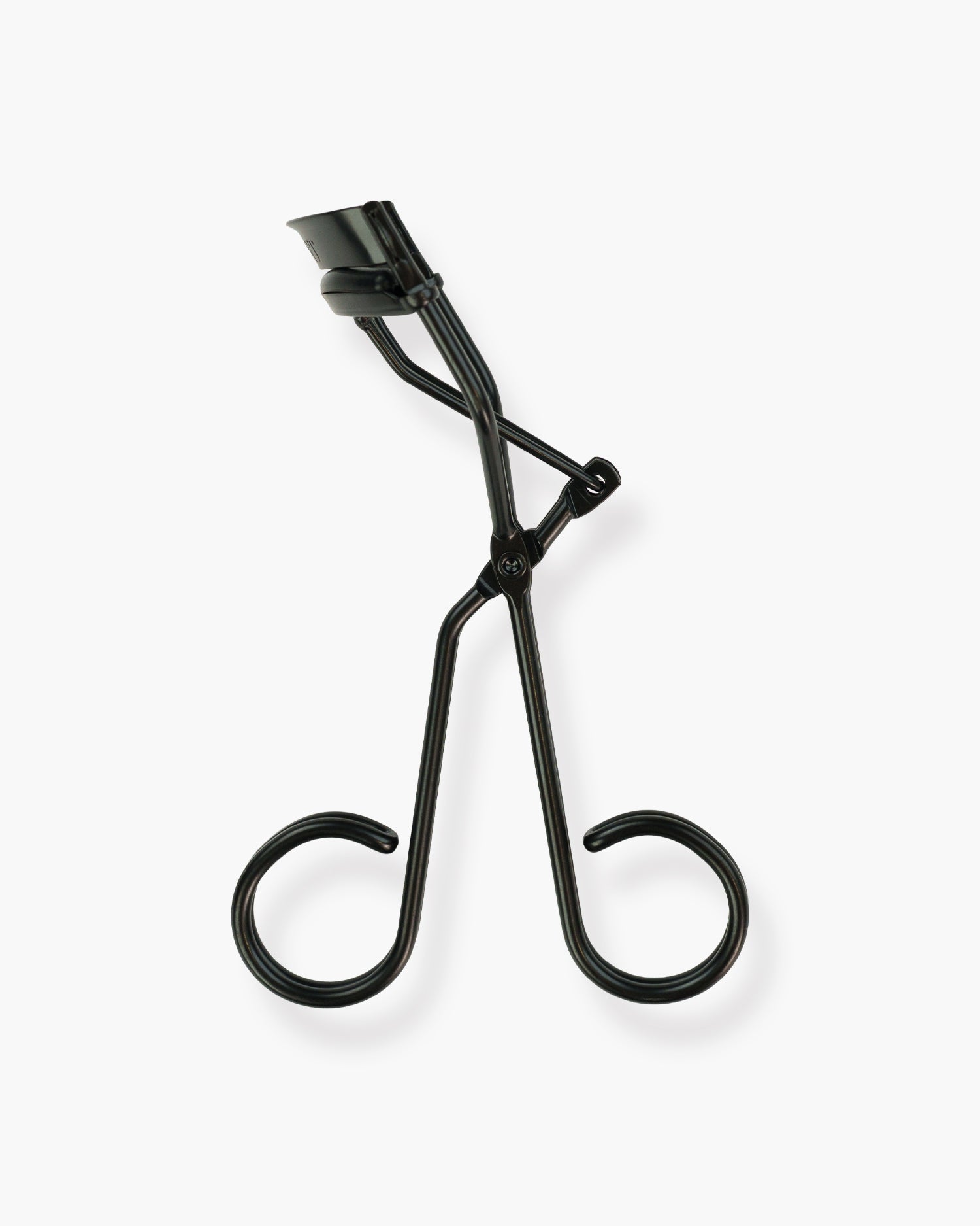 Seint Lash Curler, Halfmoon style — upright view of the all-black tool showing its rounded pad and open scissor frame