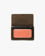 Seint Mini Compact open flat to show a single coral cream tin seated inside the black case
